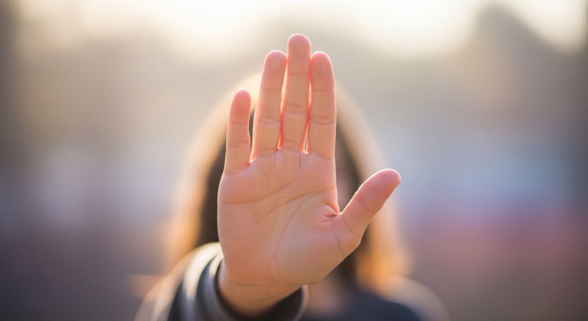 A hand making a gentle stopping gesture.